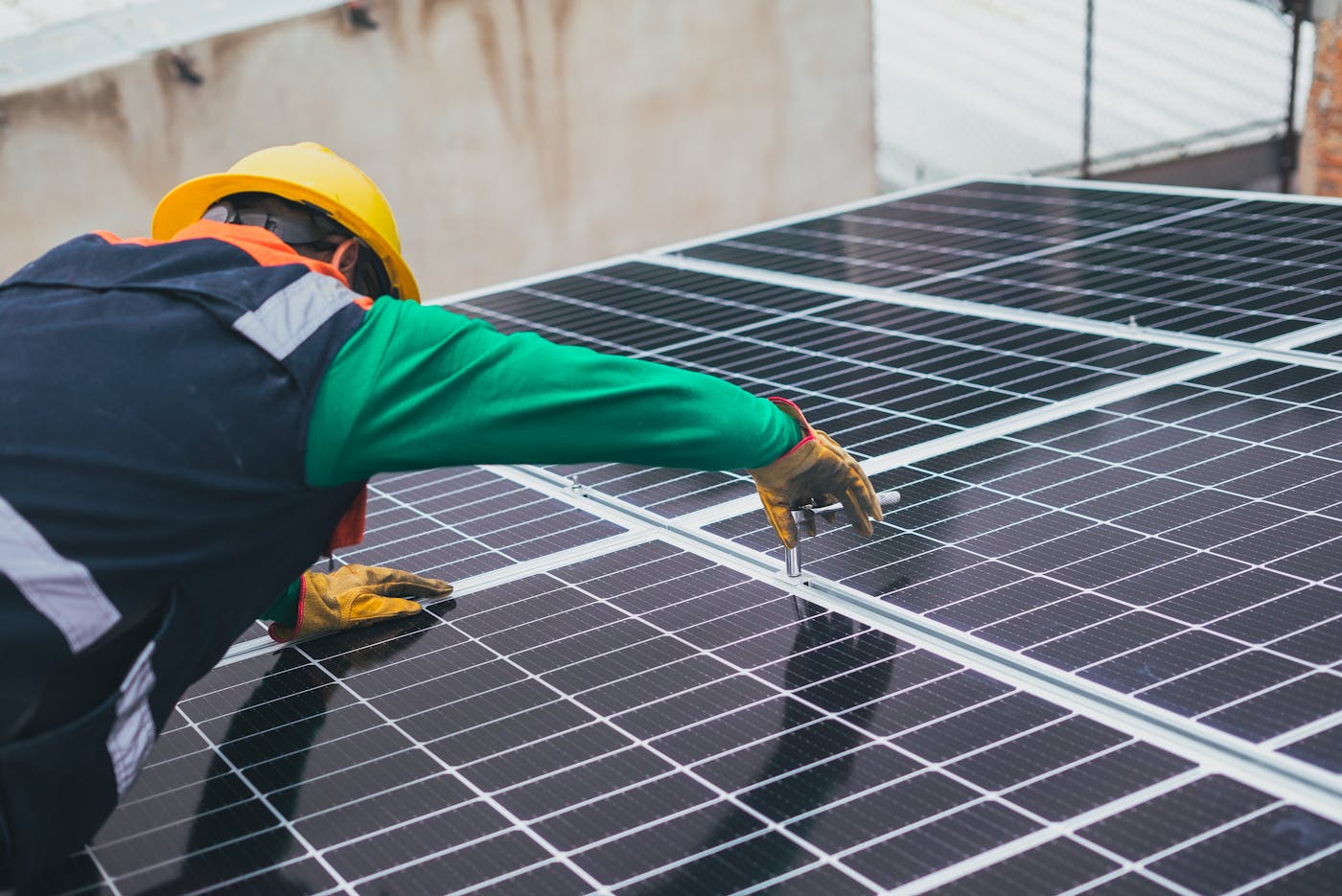 GlowHaus technician securing solar panels on a roof